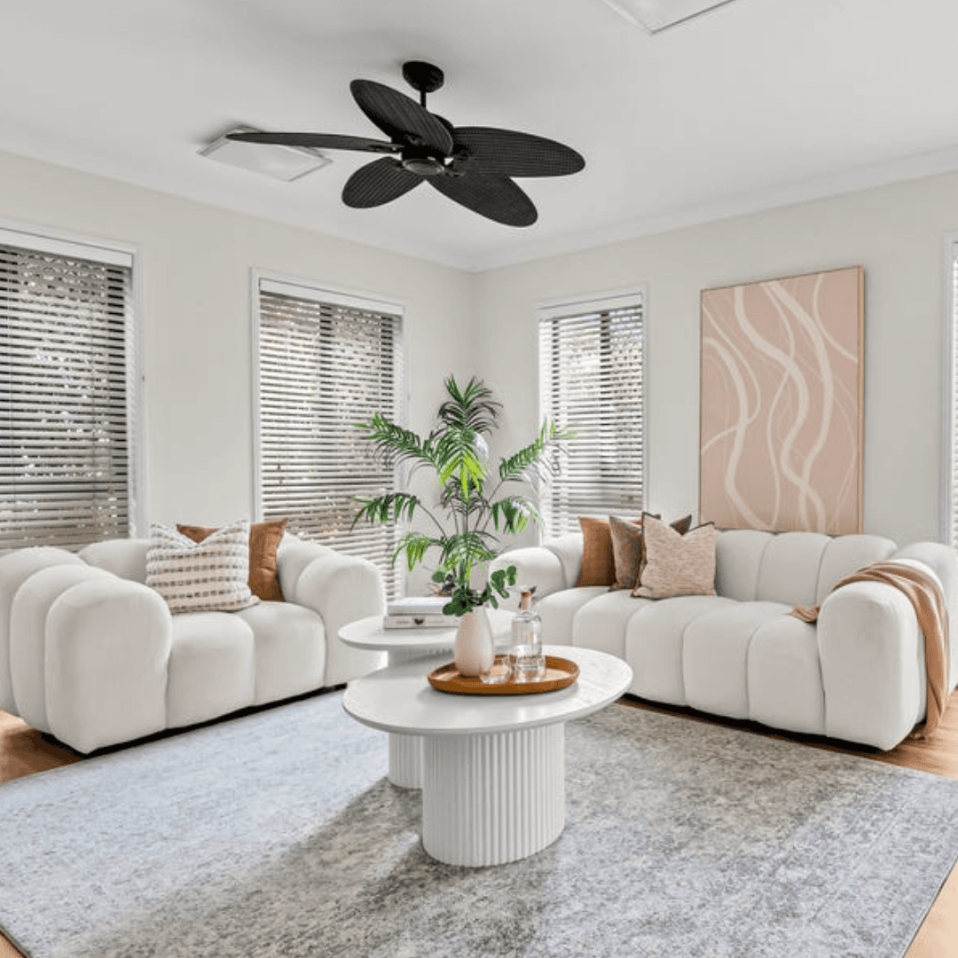 Professionally styled living room with neutral furniture and warm decorative accents