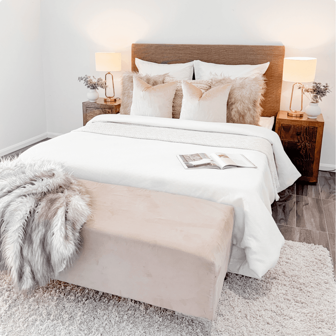 Styled bedroom with upholstered bed, layered linen and warm neutral furnishings